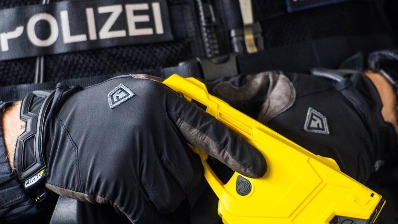 Ein hessischer Polizeibeamter hält einen Taser. Ein hessischer Polizeibeamter hält einen Taser.