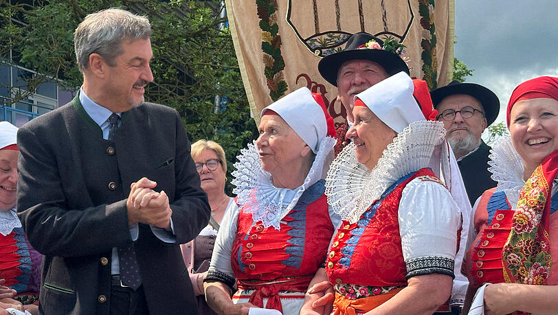 Bayerns Ministerpräsident Markus Söder (CSU) steht 2025 vor Beginn der Hauptkundgebung des Sudetendeutschen Tages zwischen Mitgliedern der Wischauer Trachtengruppe. Bayerns Ministerpräsident Markus Söder (CSU) steht 2025 vor Beginn der Hauptkundgebung des Sudetendeutschen Tages zwischen Mitgliedern der Wischauer Trachtengruppe.