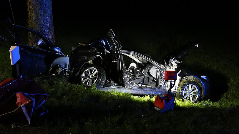 Schreckliche Bilder aus Icking: Der BMW kam von der Straße ab und prallte gegen einen Baum. Zwei 19-jährige Männer starben.