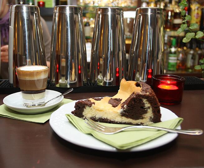 Gefleckt-geschichtetes Duo: Der &bdquo;Kaffee Haidi&ldquo; (2,20 Euro) und ein selbst gemachter Schokokuchen (2,90 Euro).