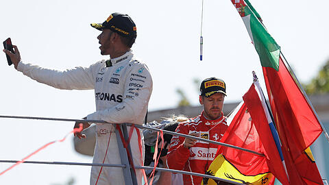 Der Brite Lewis Hamilton (links) macht auf dem Podium nach seinem Sieg ein Selfie. Rechts Sebastian Vettel.