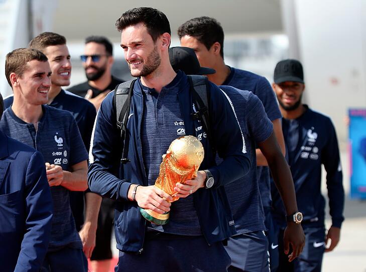 Hugo Lloris, Torhüter der französischen Fußballnationalmannschaft, hält den Siegerpokal am Flughafen Charles de Gaulle in Paris.