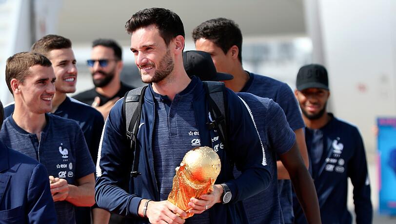 Hugo Lloris, Torhüter der französischen Fußballnationalmannschaft, hält den Siegerpokal am Flughafen Charles de Gaulle in Paris. Hugo Lloris, Torhüter der französischen Fußballnationalmannschaft, hält den Siegerpokal am Flughafen Charles de Gaulle in Paris.