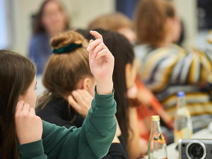 Zwei Schülerinnen melden sich im Unterricht. Foto: Annette Riedl/dpa/Symbolbild