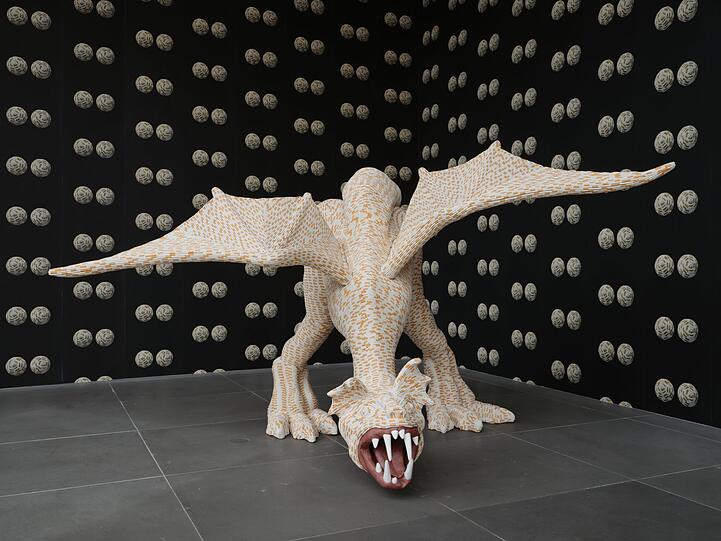 Umgeben von weiblichen Brüsten faucht dieser Drache aus Zigaretten in die Runde. "Tits in Space" hat Sarah Lucas ihre Installation genannt. Die Tapete dazu ist 2000 entstanden.