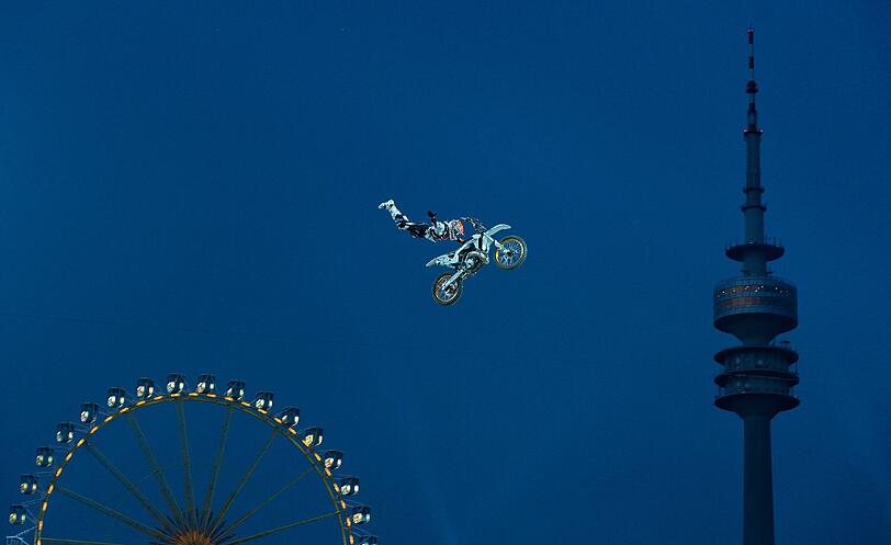Der Freestyle-Motocross-Fahrer Hannes Ackermann (Deutschland) springt am Freitagabend im Olympiastadion beim Qualifying der Red-Bull-X-Fighters Tourstopp München am Olympiaturm und einem Riesenrad vorbei.