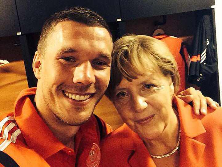 Der siegreiche Lukas Podolski mit Kanzlerin Angela Merkel