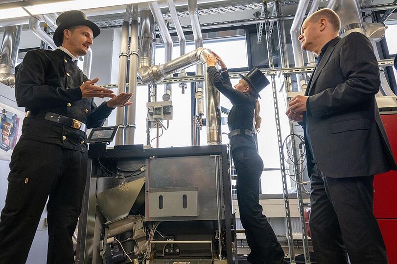 Bei der Handwerkskammer lässt sich Scholz unter anderem vonSchornsteinfegern und -fegerinnen eine Pellet-Heizung erklären.