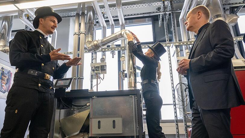 Bei der Handwerkskammer lässt sich Scholz unter anderem vonSchornsteinfegern und -fegerinnen eine Pellet-Heizung erklären. Bei der Handwerkskammer lässt sich Scholz unter anderem vonSchornsteinfegern und -fegerinnen eine Pellet-Heizung erklären.