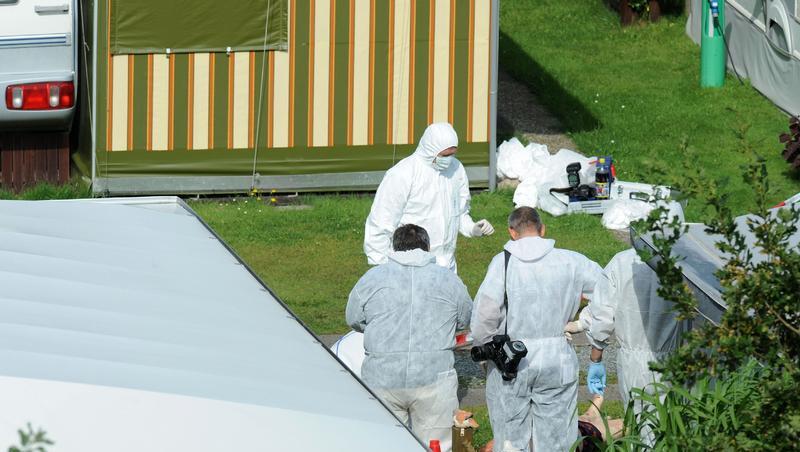 Polizeibeamte der Spurensicherung auf dem Campingplatz, auf dem das Verbrechen geschah Polizeibeamte der Spurensicherung auf dem Campingplatz, auf dem das Verbrechen geschah