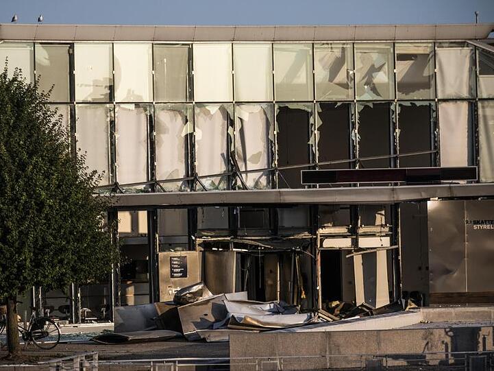 Glasreste zerbrochener Fensterscheiben, die durch eine Explosion am Eingang der dänischen Steuerbehörde zerstört wurden, hängen noch in den Fensterrahmen.