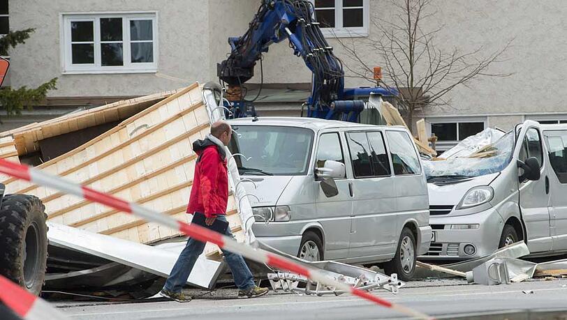 In Weilheim (Oberbayern) geht ein Mann an einem stark beschädigtem Auto vorbei. Ein Teil eines Daches wurde durch das Sturmtief "Niklas" hinweggeweht und beschädigte die Fahrzeuge. In Weilheim (Oberbayern) geht ein Mann an einem stark beschädigtem Auto vorbei. Ein Teil eines Daches wurde durch das Sturmtief "Niklas" hinweggeweht und beschädigte die Fahrzeuge.