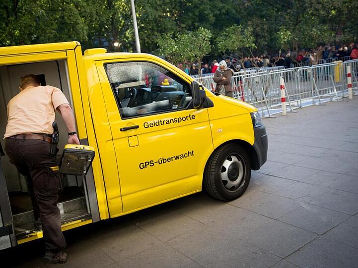 Ein Mann steht neben einem Geldtransporter. Foto: Kay Nietfeld/Archiv