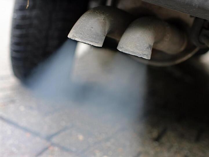 Abgase strömen aus dem Auspuff eines Fahrzeuges mit Dieselmotor.