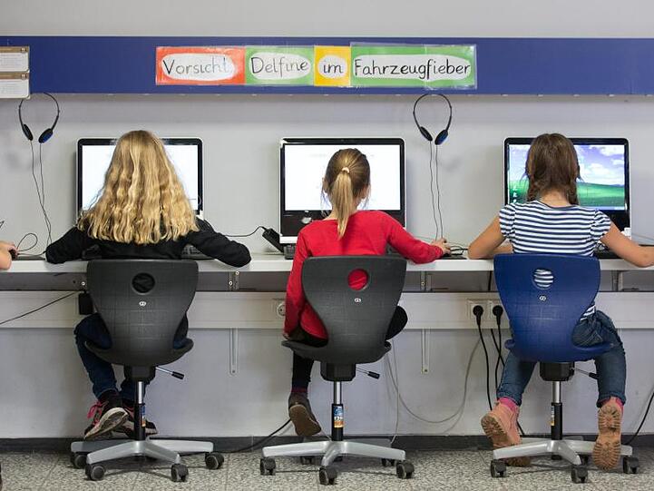 Schüler arbeiten im Klassenraum einer Grundschule an Computern.