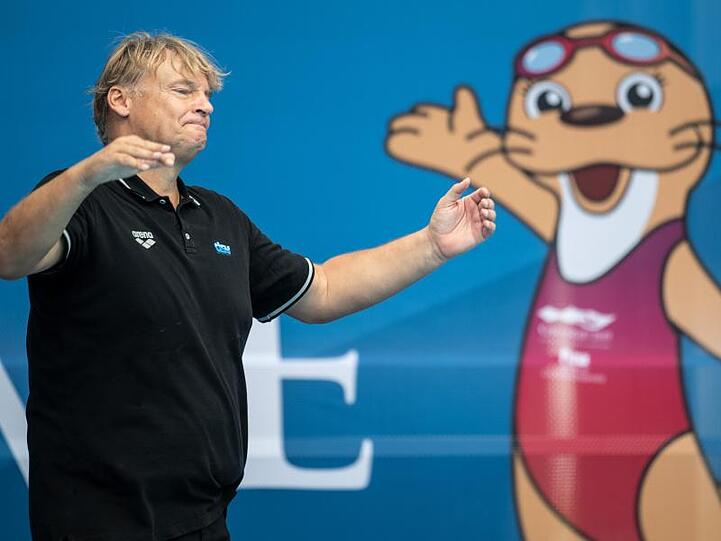 Nach dem Spiel hebt Bundestrainer Hagen Stamm vor dem Maskottchen der Veranstaltung, einem Otter, resignierend die Arme.