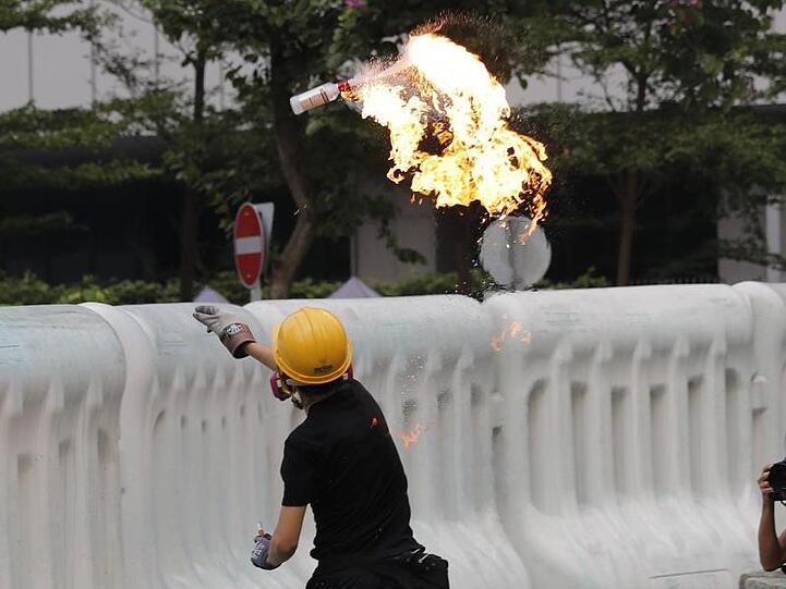 Ein Demonstrant wirft einen Molotowcocktail über eine Absperrung. Am Rande der Proteste kam es zu Zwischenfällen.