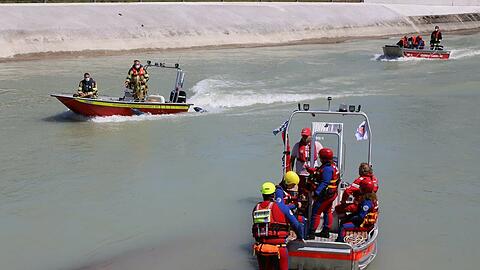 Im Innkanal suchen Rettungskräfte nach einer Frau, die in Not geraten sein soll. Mittlerweile wurde eine Leiche gefunden.