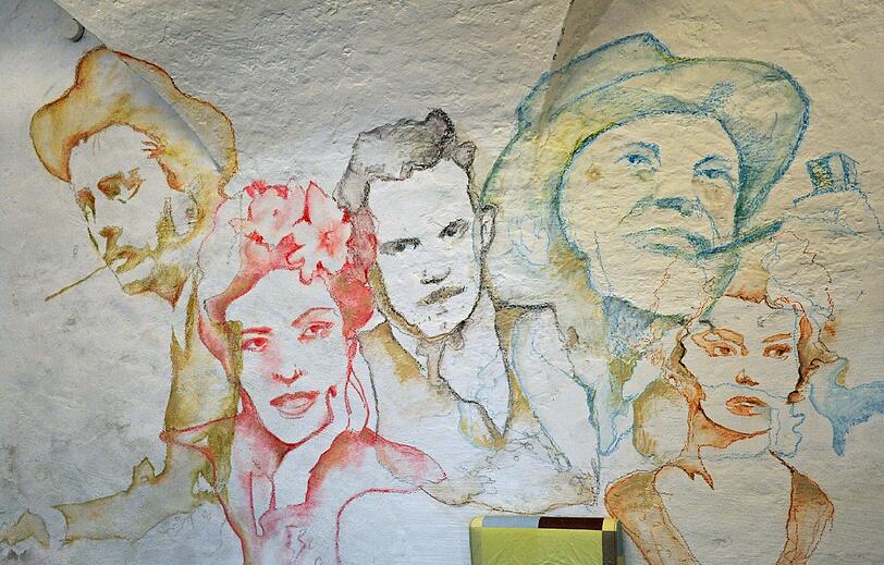 Wandschmuck: Verwegene Männer mit Hut und schöne Frauen.
