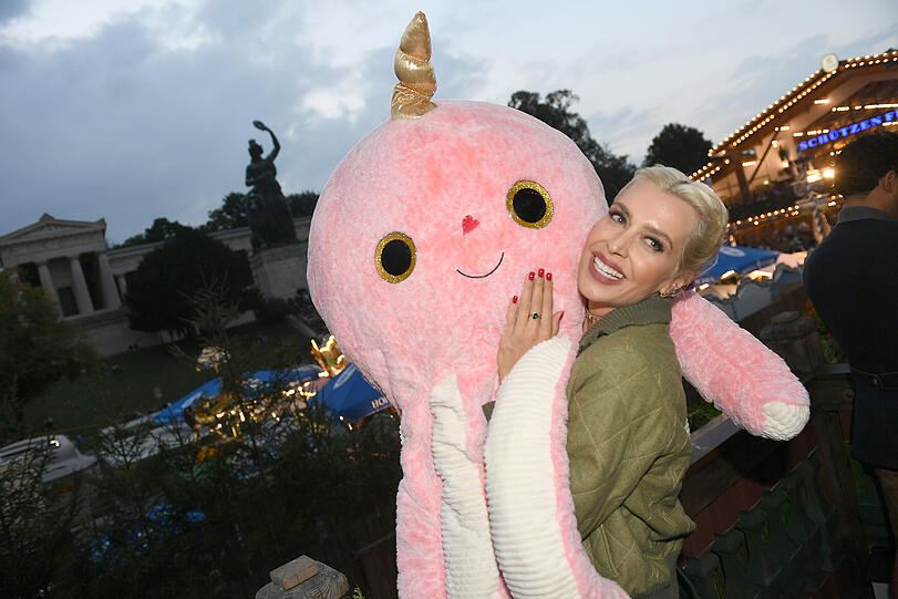 Verena Kerth feiert mit einem Oktopus auf dem Oktoberfest auf dem Balkon des Käferzelt.