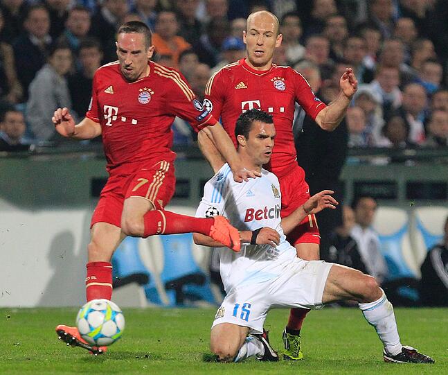 Franck Ribery und Arjen Robben kämpfen um den Ball mit Jeremy Morel (Marseille).