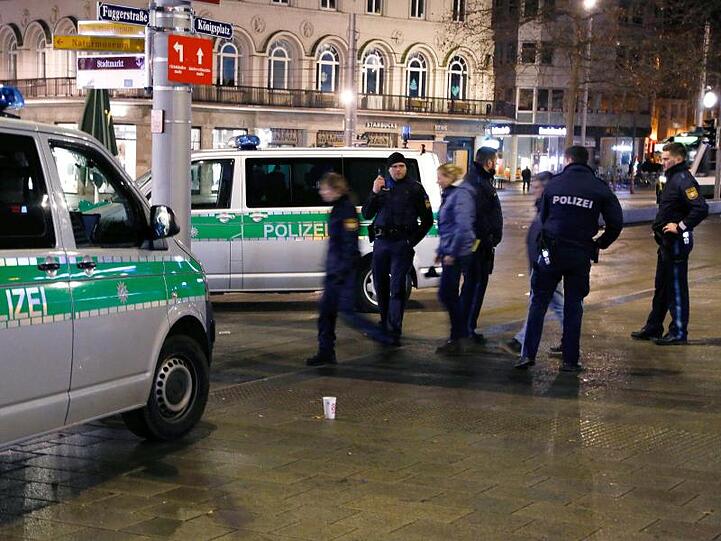 Polizisten stehen in der Nacht am Augsburger Königsplatz am Tatort. Foto: Christoph Bruder/dpa/Archivbild