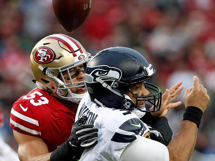 Seattle Seahawks Quarterback Russell Wilson (r) in Aktion gegen San Francisco 49ers Mark Nzeocha. Foto: Tony Avelar/AP/dpa/Archivbild