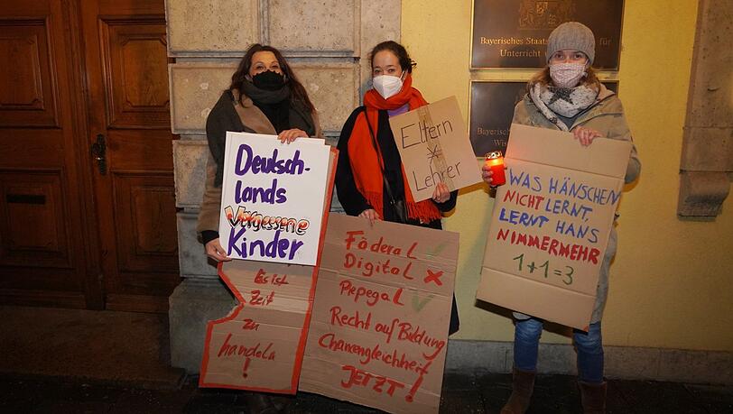 Anna Gelbert (v.l.) und ihre Mitstreiterinnen Annika Tödter und Antje Ratkovic wollen, dass das Kultusministerium Homeschooling besser macht. Dafür stellen sie einmal pro Woche selbst gebastelte Schilder vor dem Ministerium auf.