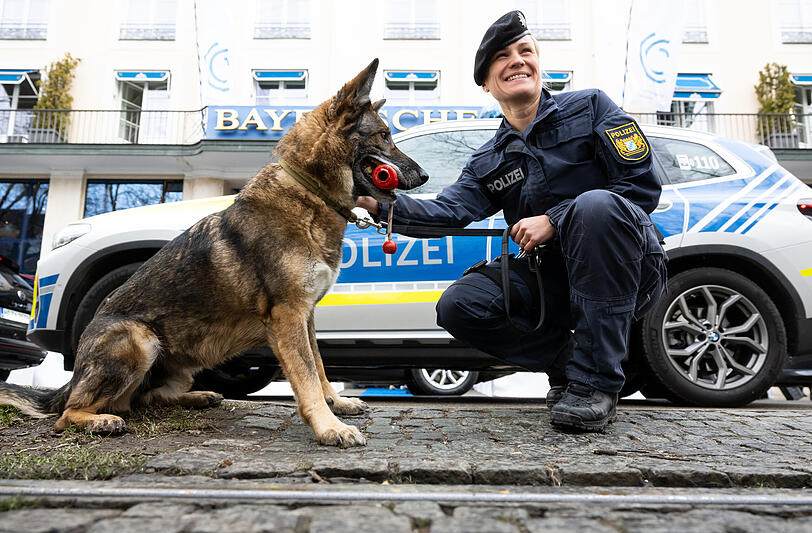 Eine Polizistin steht mit einem Sprengstoffspürhund vor dem "Bayerischen Hof".