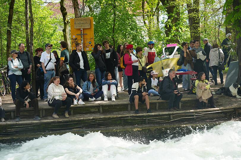 W&auml;hrend des Versuchs an der Eisbachwelle versammeln sich viele Schaulustige am Ufer.