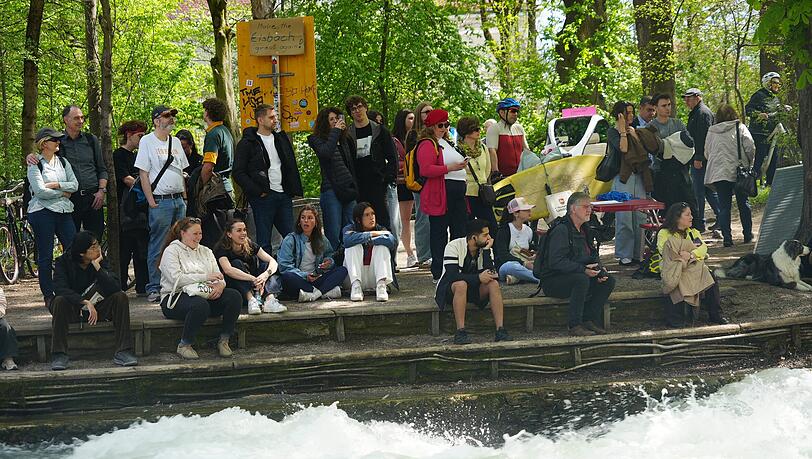 W&auml;hrend des Versuchs an der Eisbachwelle versammeln sich viele Schaulustige am Ufer.