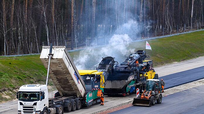 Arbeiter asphaltieren neue Abschnitte der Autobahn 14.