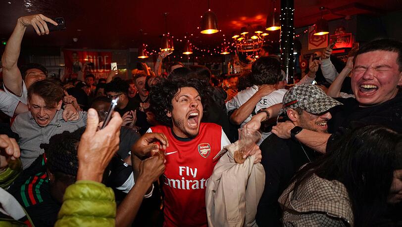 Arsenal-Anhänger feiern in einem Pub in der Nähe des Arsenal-Stadions, nachdem die Fußballmannschaft des FC Arsenal den Titel in der Premier League gewonnen hat. Arsenal-Anhänger feiern in einem Pub in der Nähe des Arsenal-Stadions, nachdem die Fußballmannschaft des FC Arsenal den Titel in der Premier League gewonnen hat.