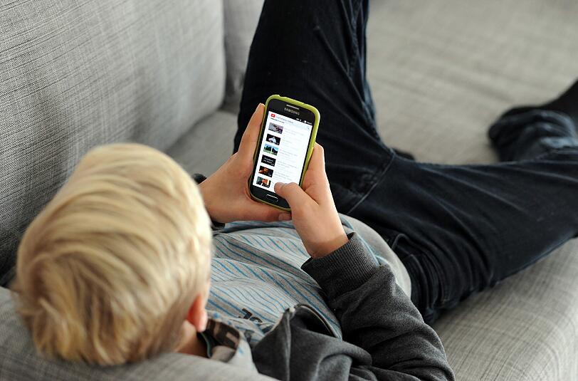 Jugendlicher mit Smartphone. Etwa 4 Prozent der 14- bis 16-Jährigen gelten als internetabhängig, Mädchen etwas häufiger als Jungs. Foto: Tobias Hase/Symbol