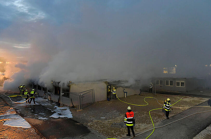 In einem Ankunftszentrum im Euroindustriepark hat ein defekter Heizlüfter einen Großbrand ausgelöst. Über dem Gelände stiegen schwarze Rauchwolken auf.