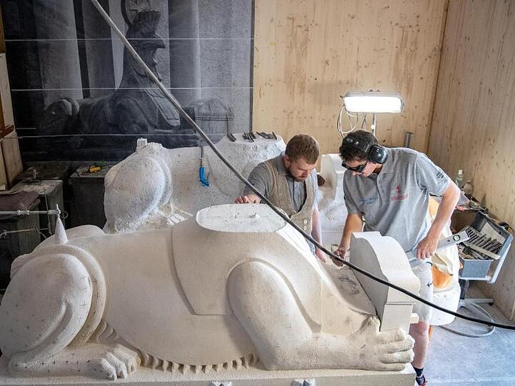 Die Steinmetzgesellen Maximilian Behrendt (l) und Benedikt Rösch vermessen die Vorlage der Sphinx-Figur. Foto: Sina Schuldt/Archivbild