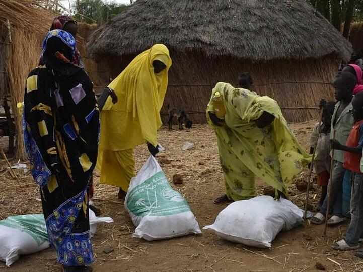 Drei Frauen nehmen im Sudan Spenden einer humanitären Organisation entgegen. Bei einer Online-Geberkonferenz kamen rund 1,8 Milliarden Dollar für den Reformprozess im Sudan zusammen.