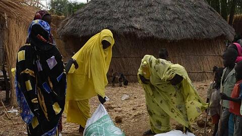 Drei Frauen nehmen im Sudan Spenden einer humanitären Organisation entgegen. Bei einer Online-Geberkonferenz kamen rund 1,8 Milliarden Dollar für den Reformprozess im Sudan zusammen.