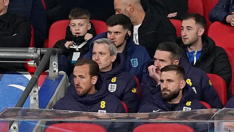 Harry Kane (l) Spieler von Bayern München und Nationalspieler von England, verfolgt das Spiel von der Tribüne.