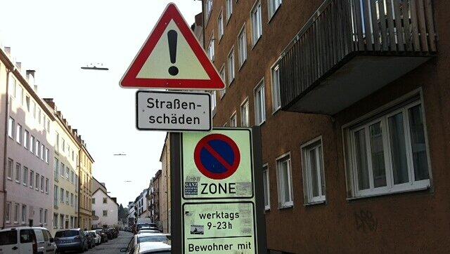 Ein Schild weist auf die beschädigte Straße hin. Ein Schild weist auf die beschädigte Straße hin.