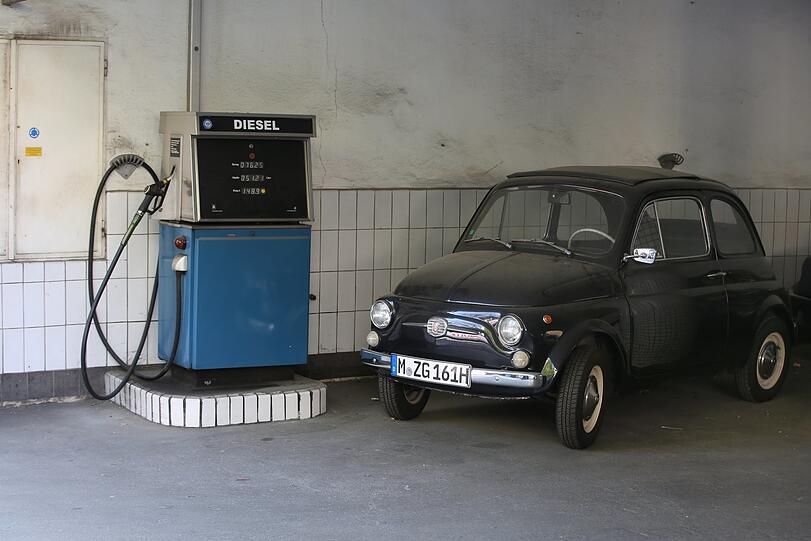 Aus einer anderen Zeit: alte Dieselzapfsäule und ein alter Fiat 500.