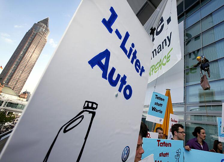 Mit Protest-Plakaten machen die Greenpeace-Aktivisten ihrem Unmut über den neuen Kleinwagen "VW Up" auf der Internationalen Automobilausstellung in Frankfurt Luft.
