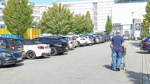 Aldi und Edeka sind an der Implerstraße Nachbarn und teilen sich diesen fußballfeldgroßen Parkplatz. Rechts im Bild ist der Aldi-Markt, links ist das Einkaufswagenhäuschen von Edeka zu sehen, ganz rechts (nicht im Bild) ist der Edeka-Einkaufsmarkt.