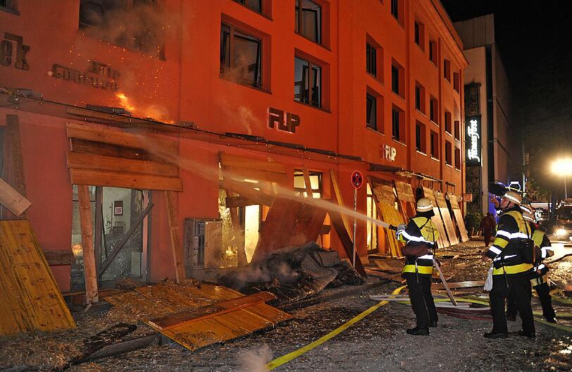 Feuer, Rauch, zerborstene Fenster - nach der Sprengung der Bombe hat die Feuerwehr viel zu tun: Umherfliegendes Stroh hatte Brände verursacht.