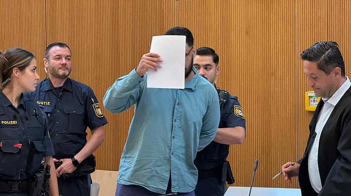 Der Angeklagte Farhad N. zwischen Justizbeamten im Gerichtssaal. Rechts neben ihm steht sein Anwalt Ömer Sahinci. Der Angeklagte Farhad N. zwischen Justizbeamten im Gerichtssaal. Rechts neben ihm steht sein Anwalt Ömer Sahinci.