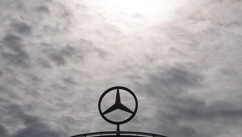 Ein Mercedes-Stern, das Logo der Marke Mercedes-Benz, steht auf einem Showroom.