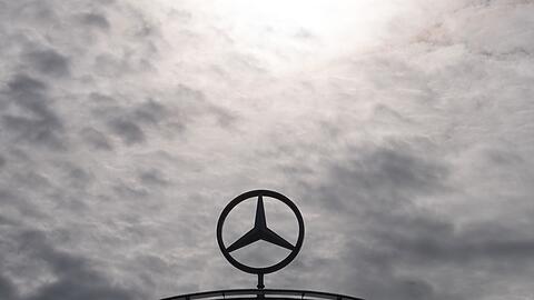 Ein Mercedes-Stern, das Logo der Marke Mercedes-Benz, steht auf einem Showroom.