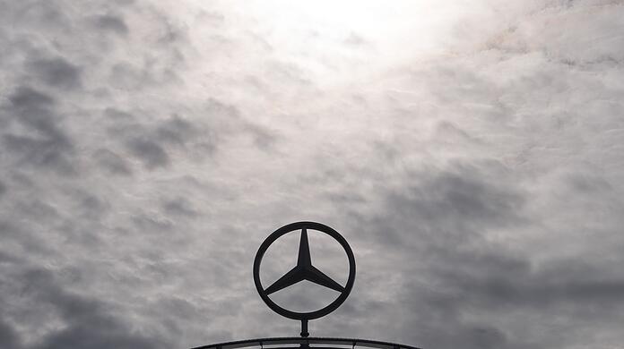 Ein Mercedes-Stern, das Logo der Marke Mercedes-Benz, steht auf einem Showroom.