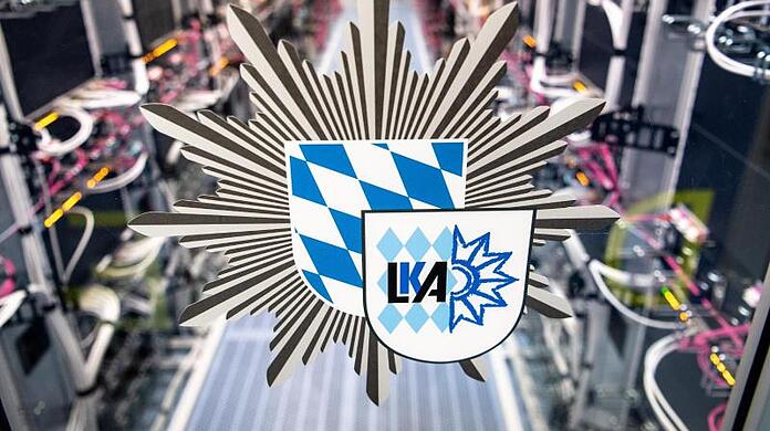Das Logo vom bayerischen Landeskriminalamt ist an der Tür zu einem Serverraum zu sehen.