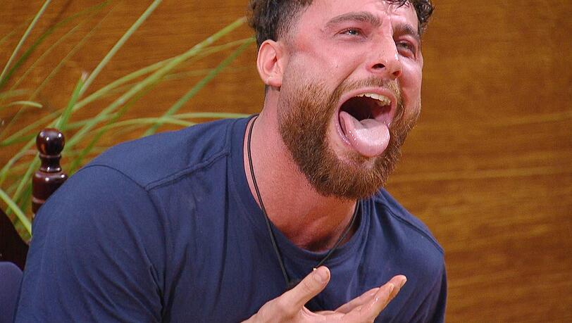 Umut Tekin bekommt vier Schnecken. Sichtbar angewidert, aber angefeuert von den anderen, w&uuml;rgt er sie runter.